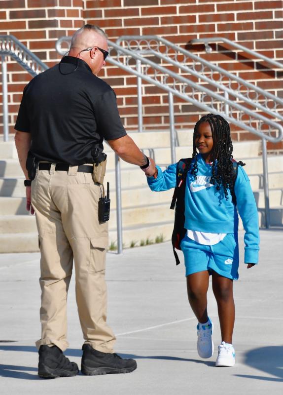 School resource officer Mark Nicholas gets a fist bump from Lewes Elementary School student Amiyah Tunnell. RON MACARTHUR